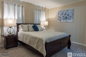 Shreveport townhouse for rent - A bedroom with a large bed and two lamps.
