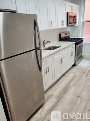 Bronx apartment for rent - A kitchen with a stainless steel refrigerator and white cabinets.