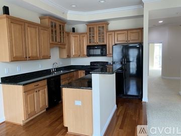 Cincinnati house for rent - A kitchen with wooden cabinets and black appliances.