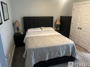Atlanta house for rent - A bedroom with a bed, a chair, a television, and a ceiling fan.