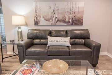 Shreveport townhouse for rent - A living room with a grey couch and a painting on the wall.