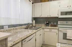 Shreveport townhouse for rent - A kitchen with white cabinets and granite countertops.