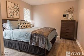 Shreveport townhouse for rent - A bedroom with a bed, dresser, and a painting on the wall.