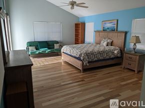 Madeira Beach house for rent - A bedroom with a bed, dresser, and a green couch.