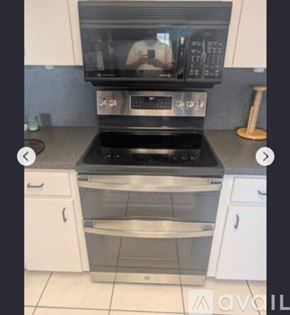 Madeira Beach house for rent - A modern kitchen with a black microwave above a stainless steel oven.