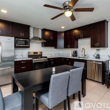 Oceanside apartment for rent - A kitchen with dark wood cabinets and a black table.