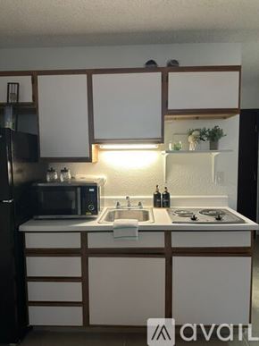 Bullhead City apartment for rent - A kitchen with white cabinets and a black refrigerator.