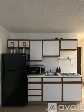 Bullhead City apartment for rent - A kitchen with a black refrigerator and white countertops.