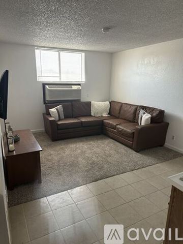 Bullhead City apartment for rent - A living room with a brown couch and a television.