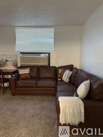 Bullhead City apartment for rent - A brown couch with a white throw blanket on it in a living room.