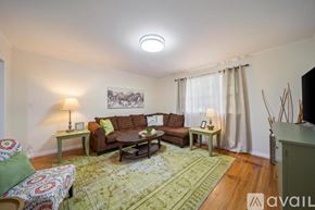 Tulsa house for rent - A living room with a couch, a chair, a table, and a rug.