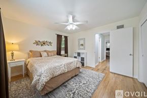Tulsa house for rent - A bedroom with a large bed and a ceiling fan.