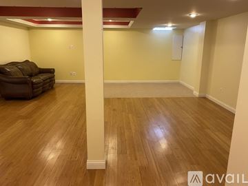 Shelby Township house for rent - A living room with a brown couch and wooden floors.
