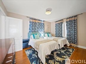 Tulsa house for rent - A bedroom with two beds and a rug in the center.