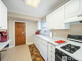 Tulsa house for rent - A kitchen with white cabinets and a white stove top oven.