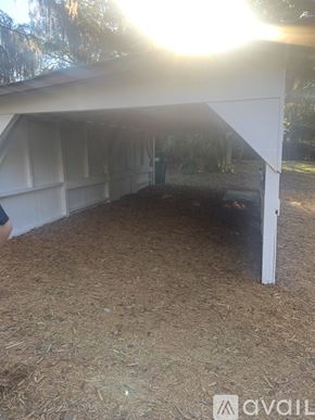 Holly Hill house for rent - A white building with a roof made of white sheets is in the middle of a field.