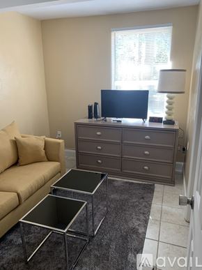 Holly Hill house for rent - A living room with a tan couch, a black TV, and a grey cabinet.
