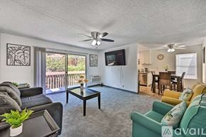 La Mesa apartment for rent - A living room with a black leather couch, a green couch, a coffee table, and a ceiling fan.
