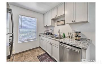 La Mesa apartment for rent - A kitchen with white cabinets and a granite countertop.