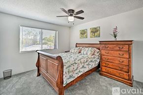 La Mesa apartment for rent - A bedroom with a bed, dresser, and a ceiling fan.