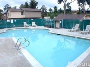 La Mesa apartment for rent - A pool with chairs around it and a fence in the background.