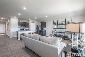 Yukon house for rent - A modern living room with a grey sofa and a kitchen area in the background.
