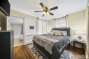 Tulsa house for rent - A bedroom with a large bed and a ceiling fan.