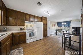 Tulsa house for rent - A kitchen with wooden cabinets and a white refrigerator.