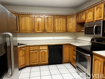 Deland house for rent - A kitchen with wooden cabinets and a black dishwasher.