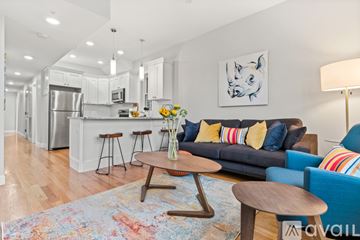 Boston apartment for rent - A modern living room with a blue couch and a wooden coffee table.