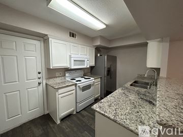 Waco apartment for rent - A kitchen with white cabinets and granite countertops.