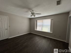 Waco apartment for rent - A room with a ceiling fan and a window.