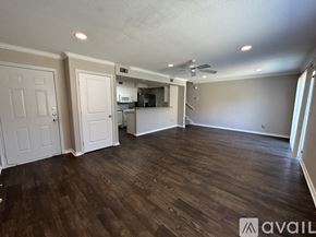 Waco apartment for rent - A spacious room with wooden flooring and a ceiling fan.