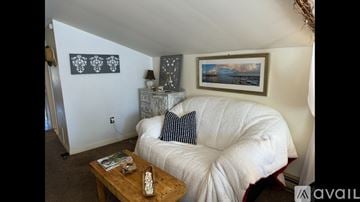 Newburyport apartment for rent - A living room with a white couch and a wooden coffee table.