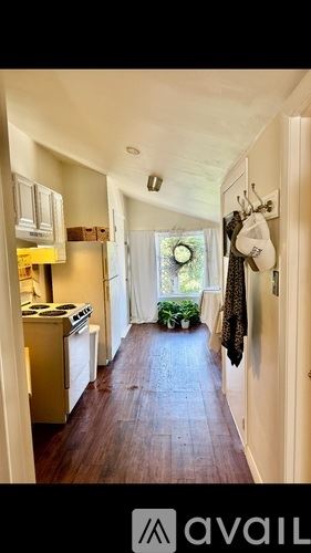 Newburyport apartment for rent - A kitchen with a stove top oven and a wooden floor leading to a door.
