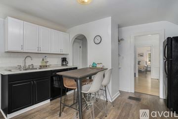 Grand Rapids apartment for rent - A kitchen with black cabinets and a wooden table.