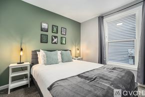 Grand Rapids apartment for rent - A bedroom with a bed, nightstand, and pictures on the wall.