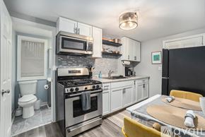 Grand Rapids apartment for rent - A modern kitchen with a stove top oven and microwave above it.