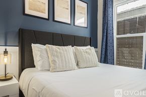 Grand Rapids apartment for rent - A bed with white pillows and a grey headboard with a lamp on the side table.