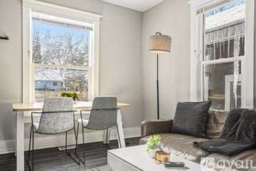 Grand Rapids apartment for rent - A living room with a grey couch, a table with two chairs, and a floor lamp.