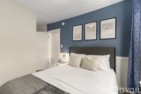 Grand Rapids apartment for rent - A bedroom with a bed, pillows, and pictures on the wall.