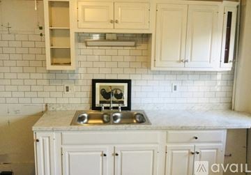 Newburyport apartment for rent - A kitchen with white cabinets and a marble countertop.