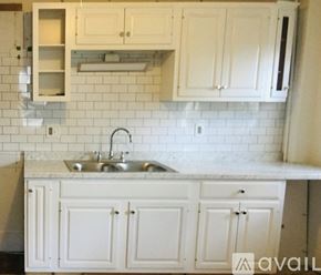 Newburyport apartment for rent - A kitchen with white cabinets and a marble countertop.