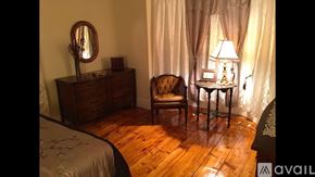 Newburyport apartment for rent - A bedroom with a bed, chair, and lamp.