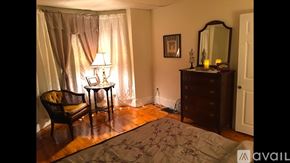 Newburyport apartment for rent - A room with a chair, a table, a dresser, and a mirror.