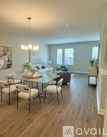 Lutz townhouse for rent - A modern living room with a glass table and white chairs.