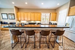 Palm Desert house for rent - A kitchen with brown chairs and a countertop.