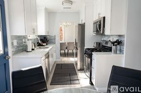 Fullerton house for rent - A kitchen with white cabinets and a black stove top oven.