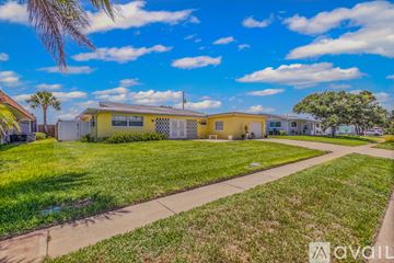 Ormond Beach house for rent - A living room with a white sofa and a dining table with chairs.