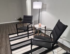 Saline apartment for rent - A black chair is placed in front of a white lamp and a small table with a lit candle on it.
